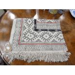 Woven rug with cream ground and geometric pattern