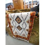 (21) South American style cream ground rug with an orange border and diamonds