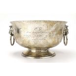 An early 20th century hammered silver rose bowl with a pair of lions head ring handles,
