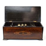 A late 19th century German cylinder music box with three bells, housed within a walnut,