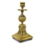 A Victorian brass candlestick of Gothic design with a scrolled pierced work body and four bearded