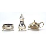 An early 20th century silver three piece cruet set having gadrooned decoration and paw feet,