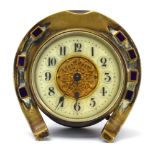 A late 19th/early 20th century timepiece with an enamelled face and a brass horseshoe case, d.