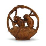 A Japanese wood carving modelled as a pair of rabbits inside a fruit basket, h.