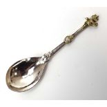 A Middle Eastern metalware serving spoon with raised bird decoration, l.