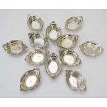 A set of twelve Continental stamped silver dishes of oval form with scrolled and foliate borders, w.