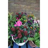 2 white baskets of mixed flowers