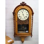 Ornately cased wall clock with pendulum and key