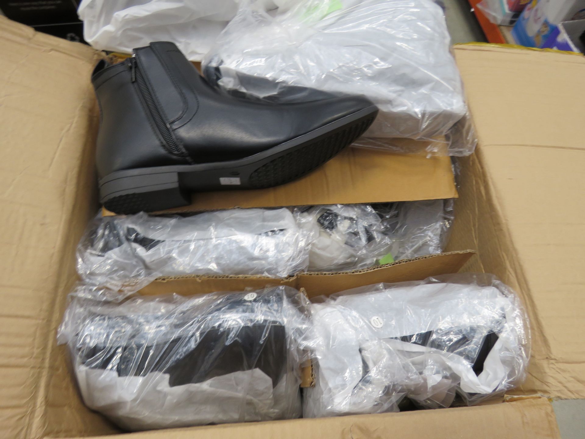 Box containing pairs of mens black boots in various sizes