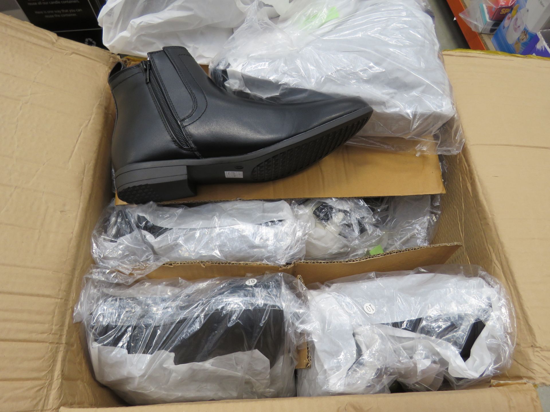 Box containing pairs of mens black boots in various sizes