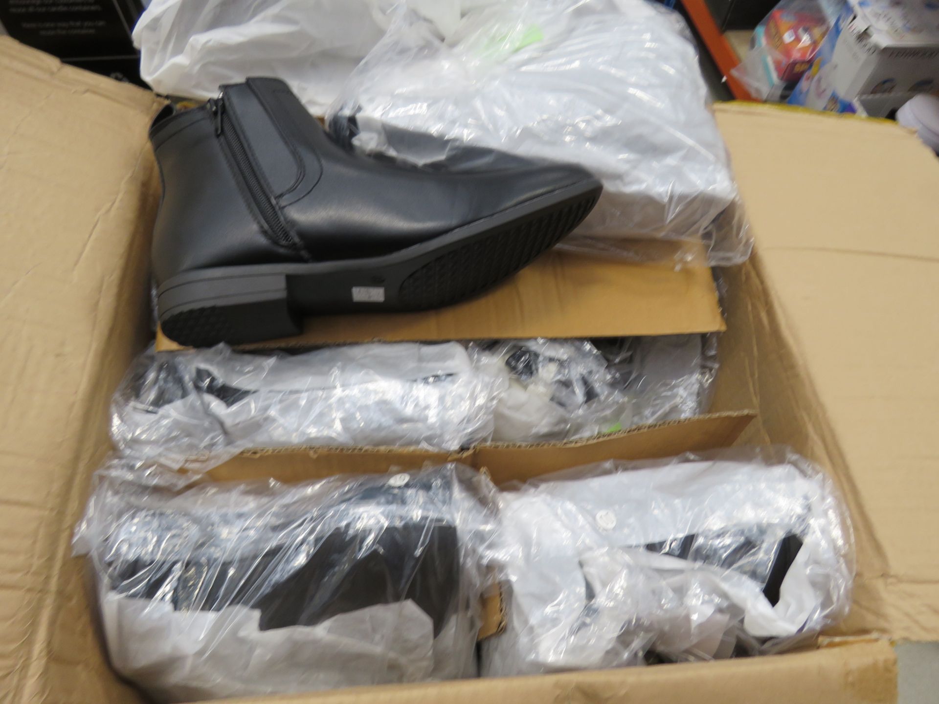 Box containing pairs of mens black boots in various sizes