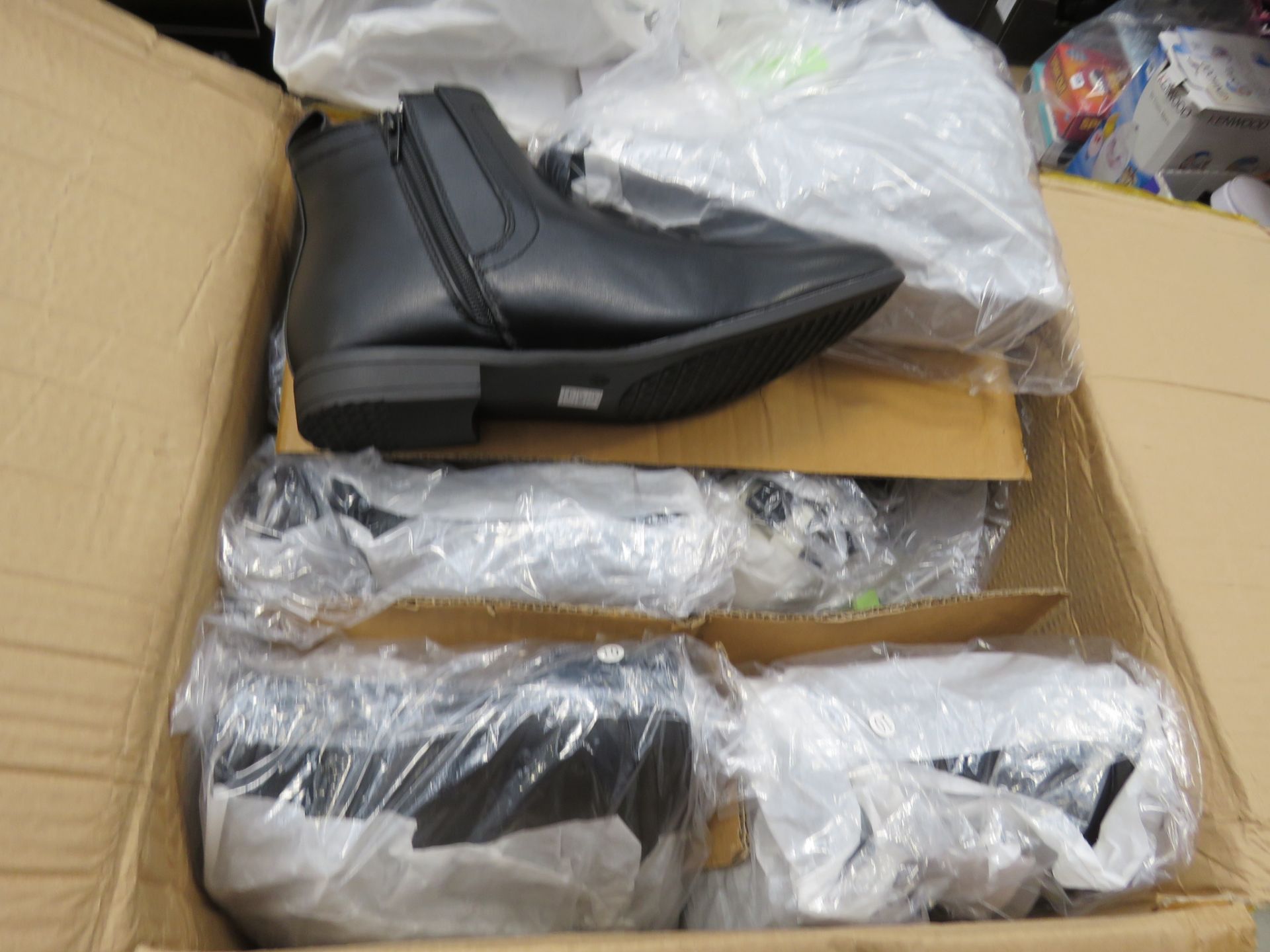 Box containing pairs of mens black boots in various sizes