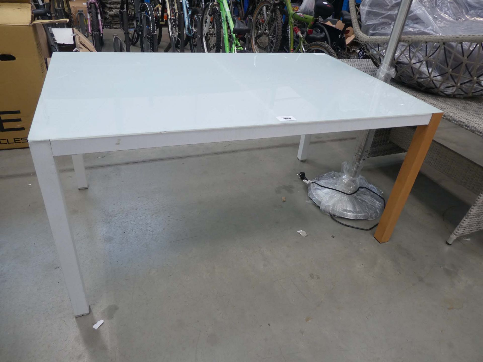 White glass top table on harlequin supports