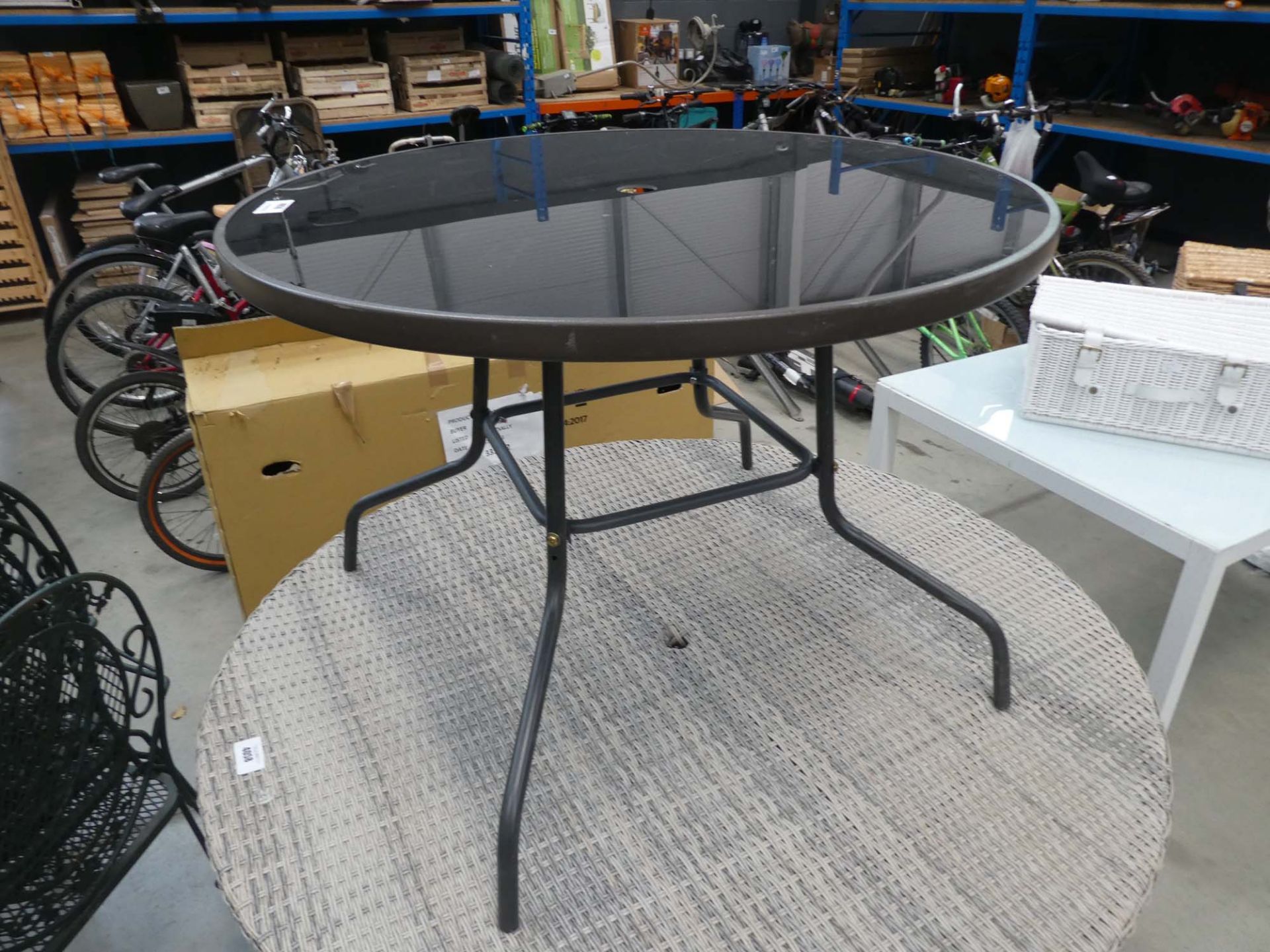 Smoked glass circular garden table on brown supports