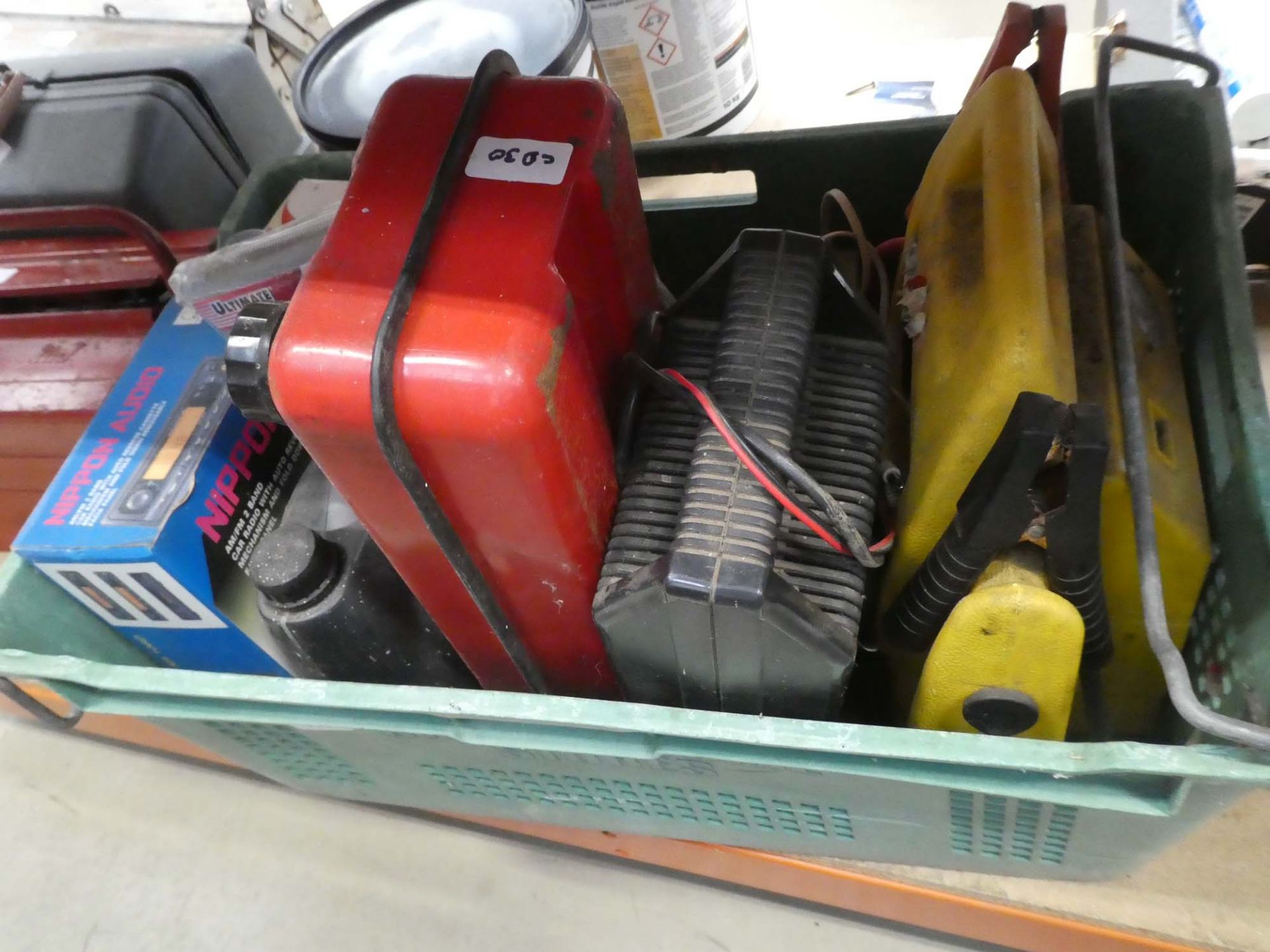 Plastic crate containing car radio, jump leads, fuel can, jump starter, charger etc