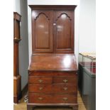 6rr Oct A Georgian mahogany bureau bookcase, the two doors enclosing a stationary cupboard, over a