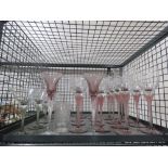 Cage containing pink stemmed wine glasses, martini glasses and tumblers