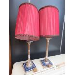 Pair of brass finished table lamps with red pleated shades