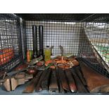 Cage containing shotgun stock, leather belts, torches, horse shoe, vice and pipe