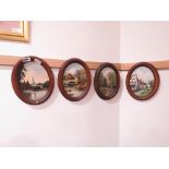 Four oval painted panels of village and woodland scenes