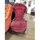 Carved wooden nursing chair in red floral fabric