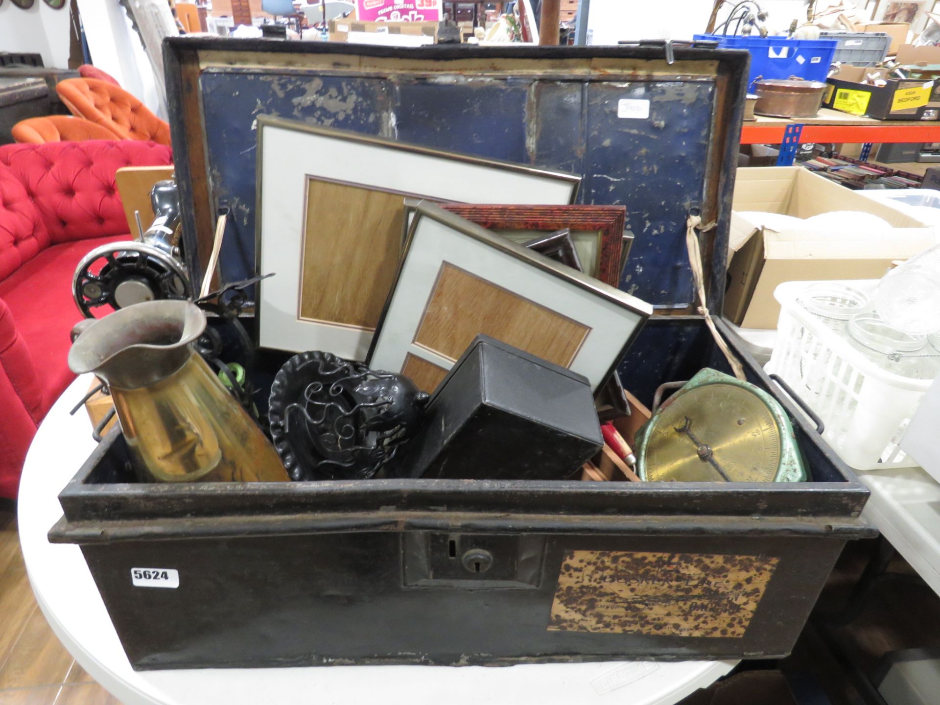 Tin trunk with picture frame, scales, brass jug, treen, loose cutlery and household goods