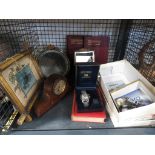 Cage containing wristwatches, books on human anatomy and a print of a mantleclock and mirror