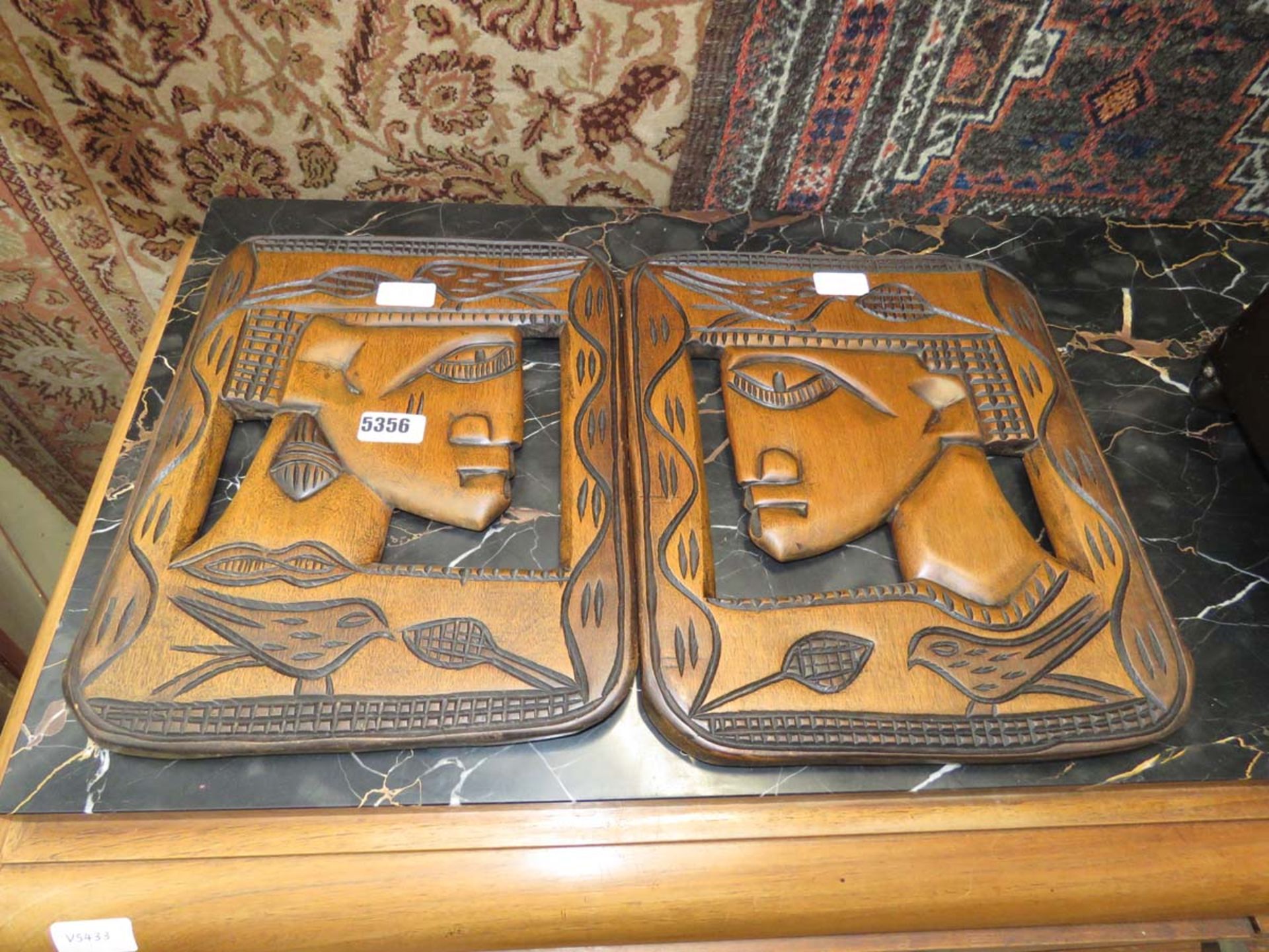 2 carved wooden wall panels with faces in the profile