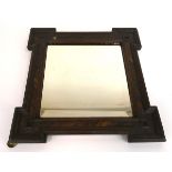 A late 19th/early 20th century wall mirror, the square bevelled plate within a castellated frame,