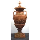 Statuary: a terracotta three-section garden urn surmounted by a pine cone and decorated with