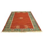 A 1930/40's flat weave rug, the red ground decorated with stylised corn,