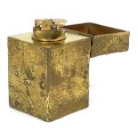 A 1970's brass finished table lighter, the body in the form of moon craters,