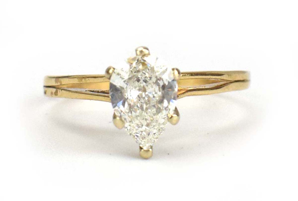 A 14ct yellow gold ring set teardrop diamond in a six claw setting within a split band shank,