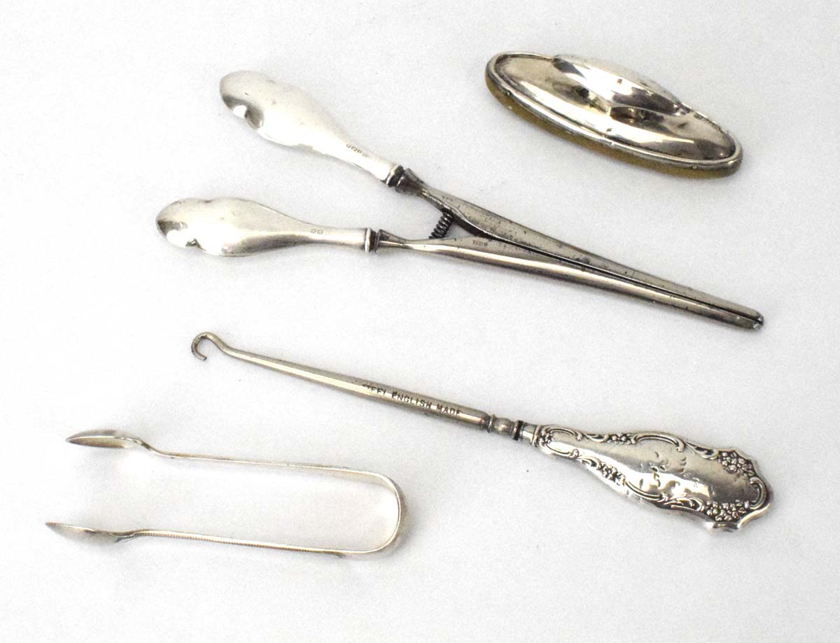 Four early 20th century silver handled dressing table items comprising two button hooks,