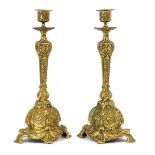 A pair of George III brass candlesticks heavily decorated with floral motifs and scrolls, c.