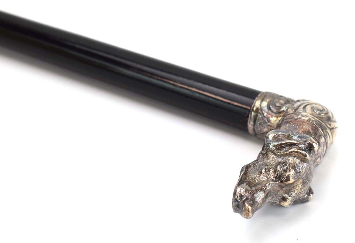 An ebonised walking cane with a Russian silver mounted pommel modelled as a hound,