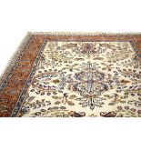 A hand-made woolen carpet, the beige and blue ground with floral motifs,