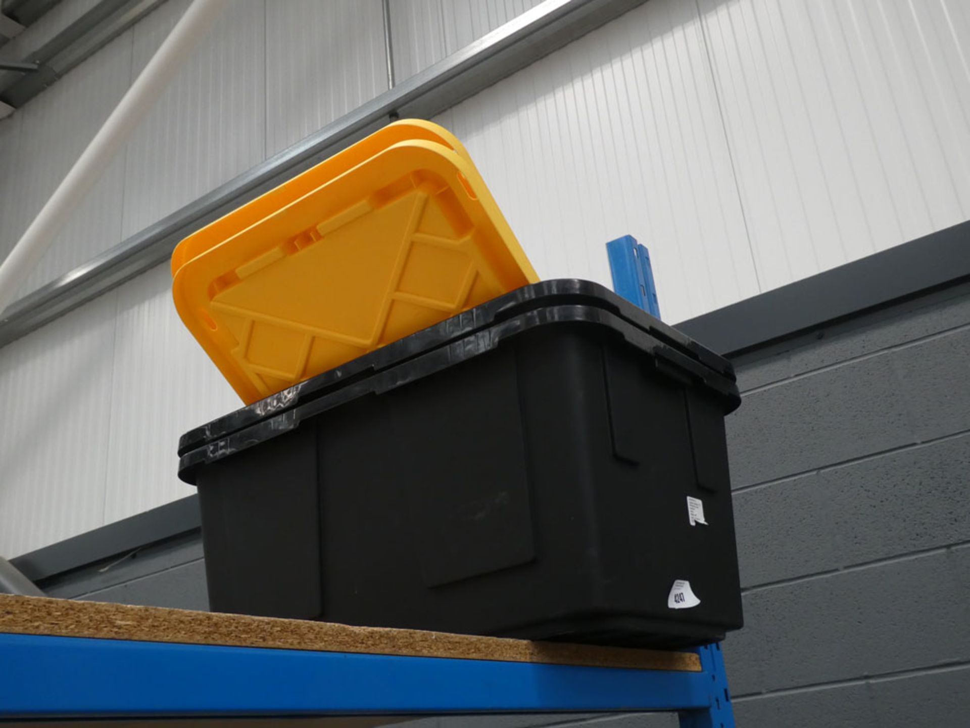 2 black and yellow lidded storage boxes