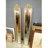 Pair of long thin rectangular gilt framed mirrors with floral garnish