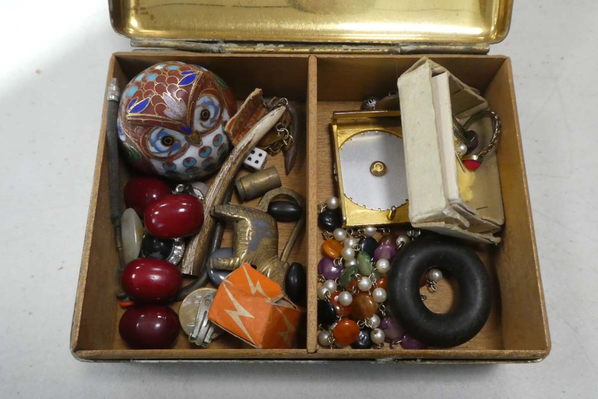 Brass tin containing various collectable items inc. pins, bracelets etc