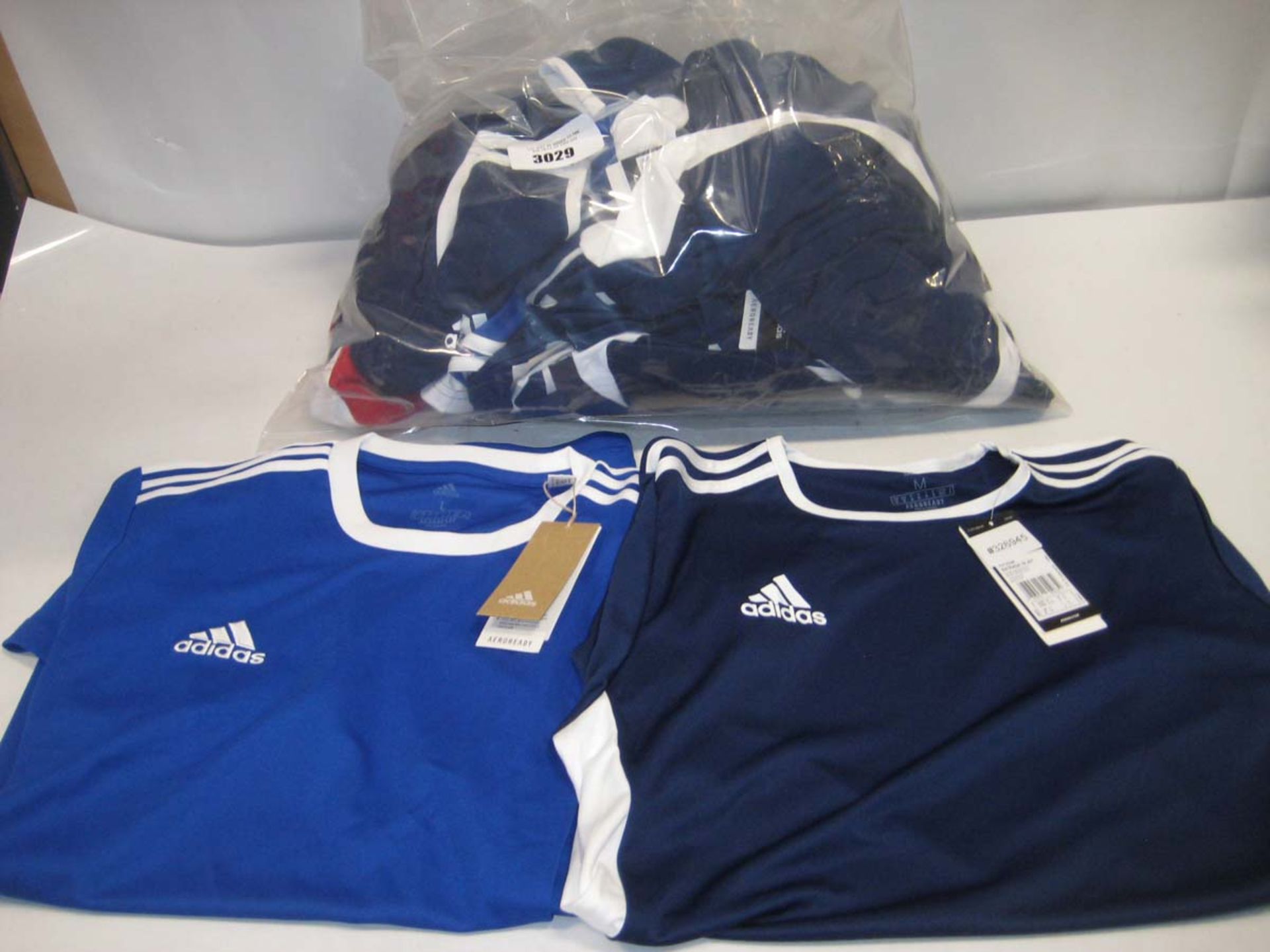 Bag containing approx. 20 Adidas tops in blue and one in red
