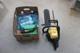 Yellow McCullough chainsaw and cardboard box with fuel can and oils