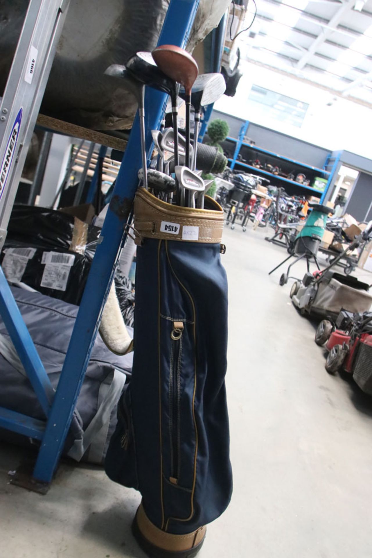 Blue and gold golf bag with a quantity of assorted clubs