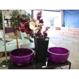Two large circular purple planters together with one further planter and a number of artificial