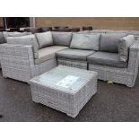 Grey rattan 4 piece L-shaped garden sofa with small glass coffee table