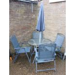 Circular glass top garden table with 4 blue metal mesh garden chairs and parasol