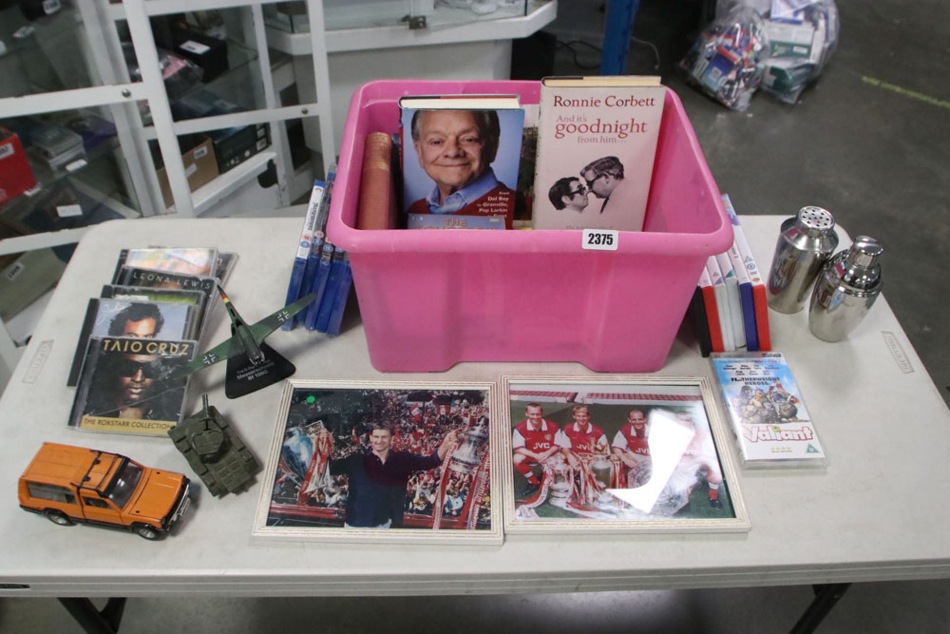 Pink plastic crate containing various bric a brac