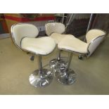 Three cream leather effect swivel bar stools