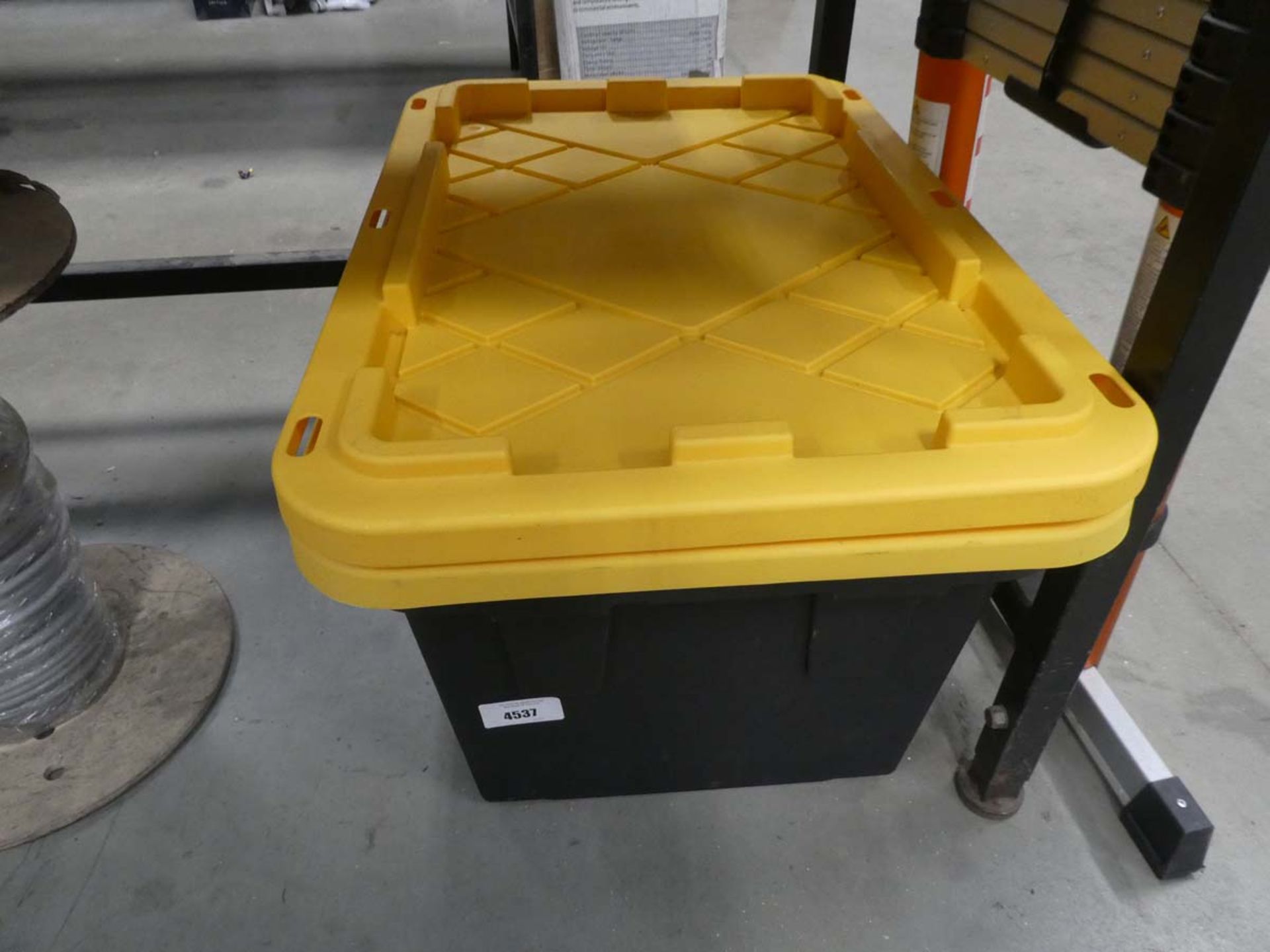 2 yellow lidded black plastic crates