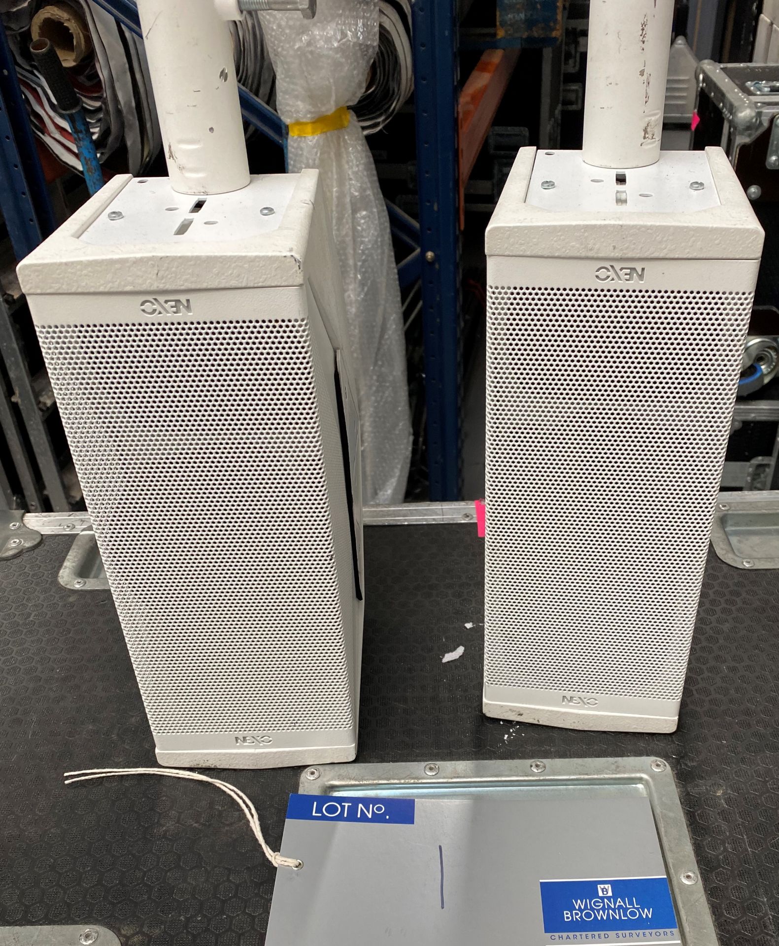 A Pair of NEXO ID24 Speakers in white fitted with pole mount and mobile flight case (in working